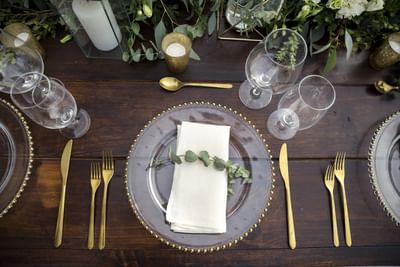 Elegant table setting with gold cutlery on a wooden table at Villa Premiere Boutique Hotel & Romantic Getaway