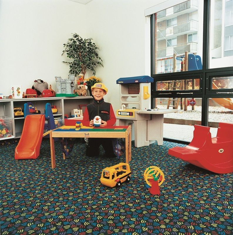 Un garçon joue dans l’aire de jeux intérieure du Cartier Place Suite Hotel