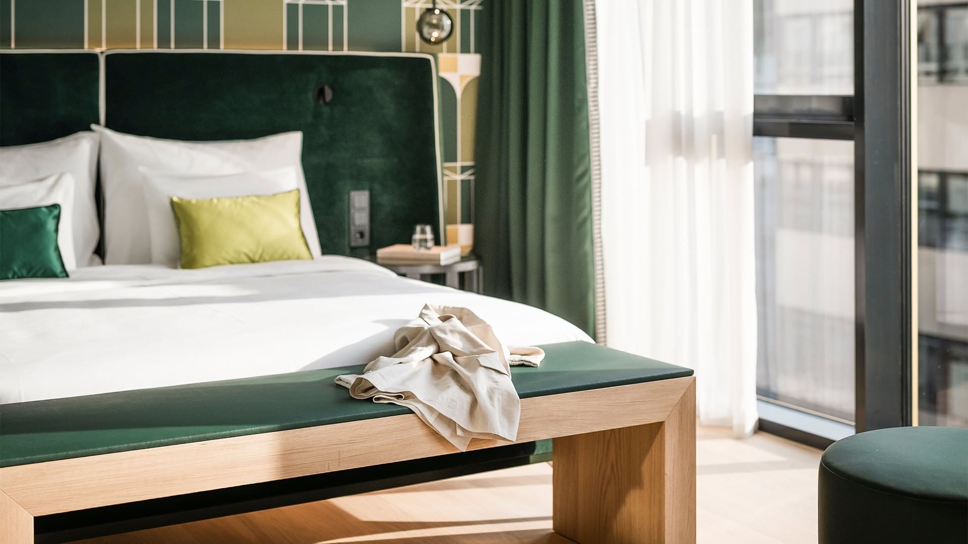 Junior Suite mit Bett, Bank und Balkon im Falkensteiner Hotel Bozen WaltherPark in Bolzano.