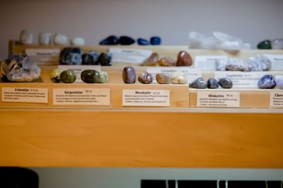Labeled crystal stones and polished gemstones on wooden display shelves for sale at La Tourelle Hotel and Spa