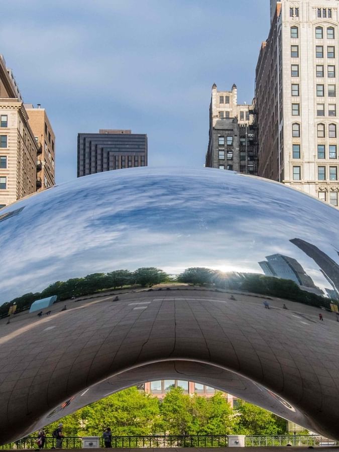 Cloud Gate sculpture reflecting clouds and city buildings near Warwick Allerton Chicago