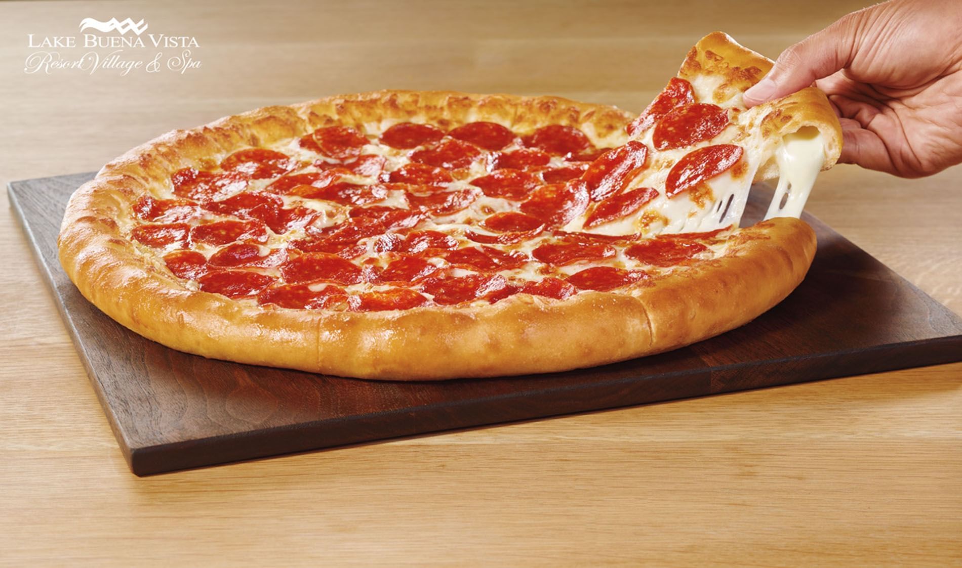 Pulling a pizza slice from a stuffed crust pizza at Lake Buena Vista Resort Village & Spa