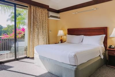 Large bed & balcony in Garden Deluxe at Dinah's Garden Hotel