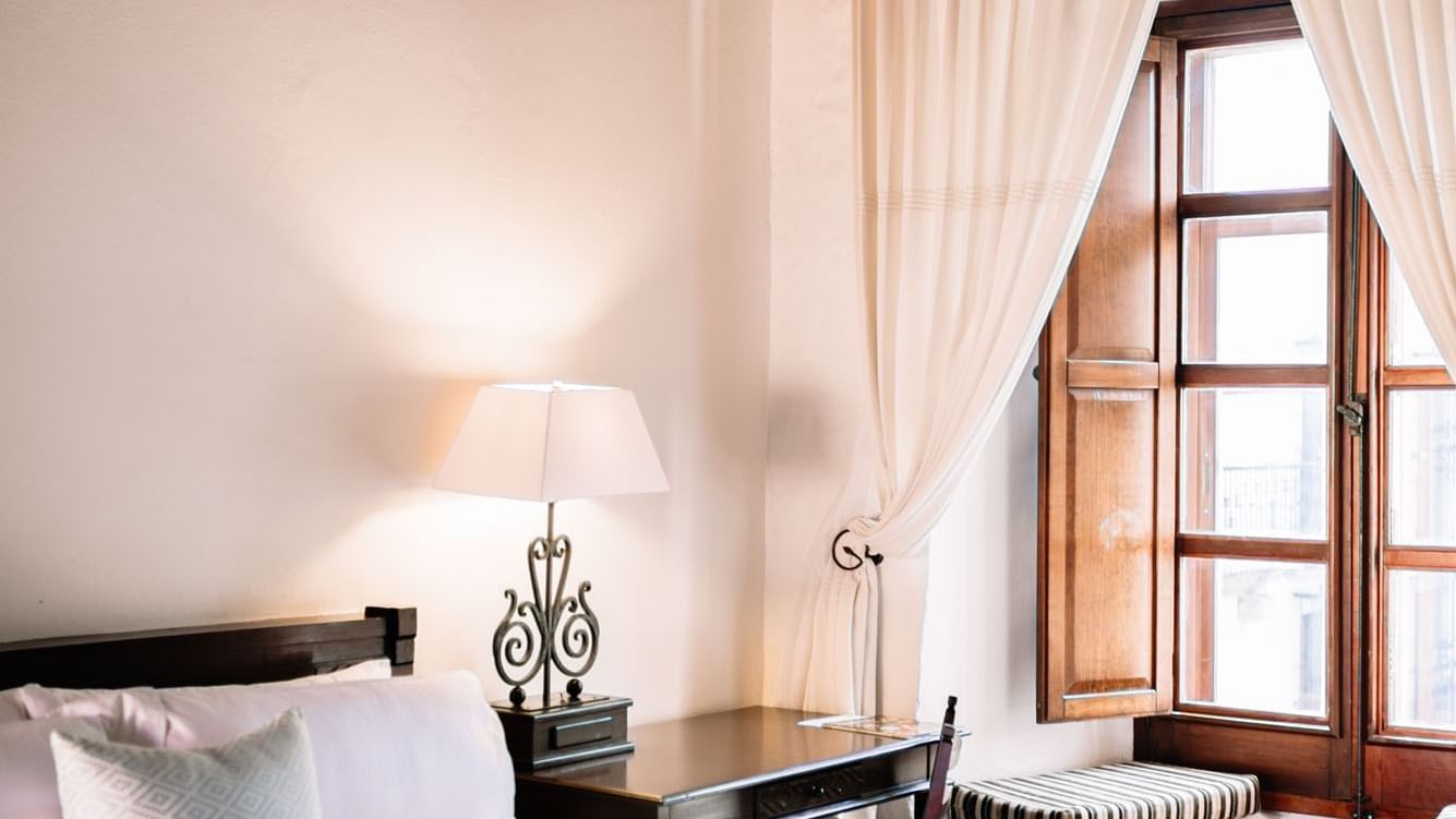 Nook and work desk by the cozy bed with plush pillows in the King Superior Suite at Quinta Real Oaxaca