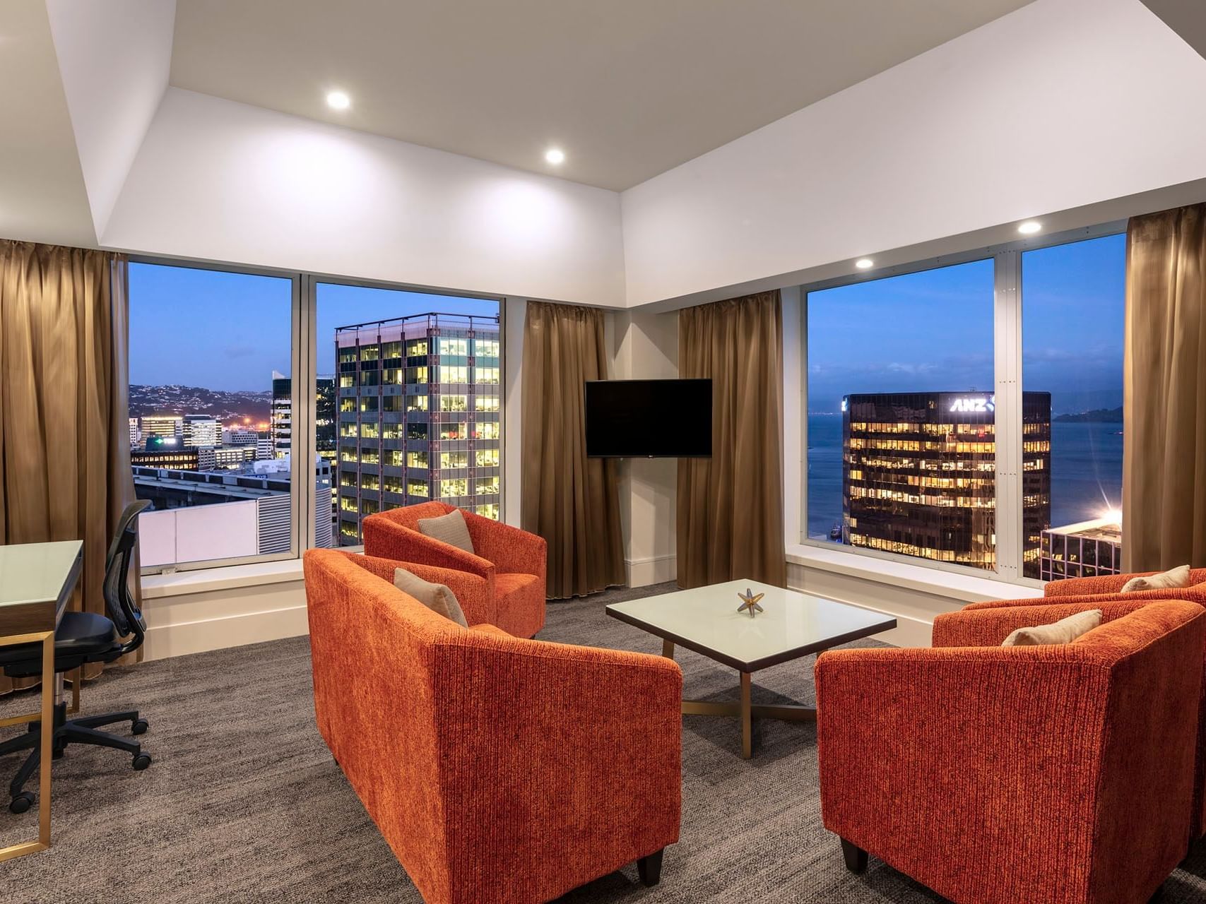 King Suite with Harbour View room lounge area with city view at James Cook Hotel Grand Chancellor