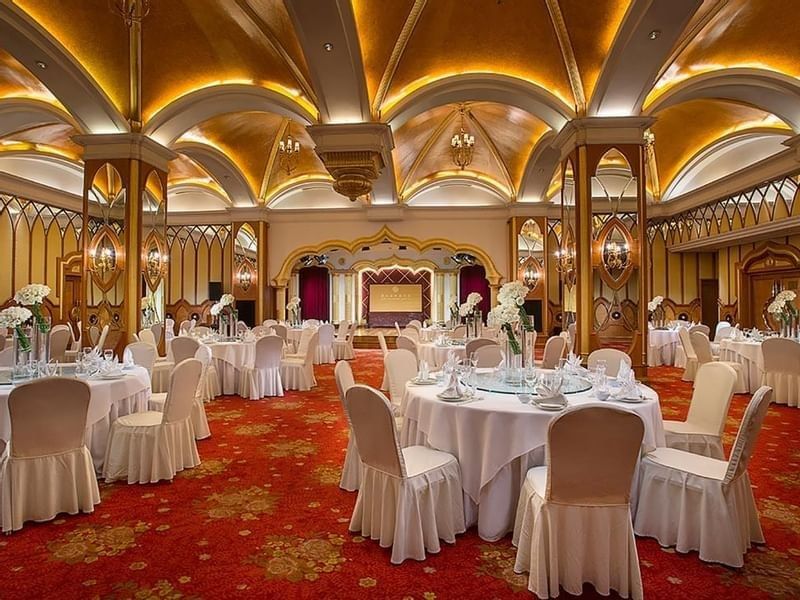 Celebrity Banquet Room with banquets under arched gold ceilings & red floral carpet at Celebrity International Grand Hotel
