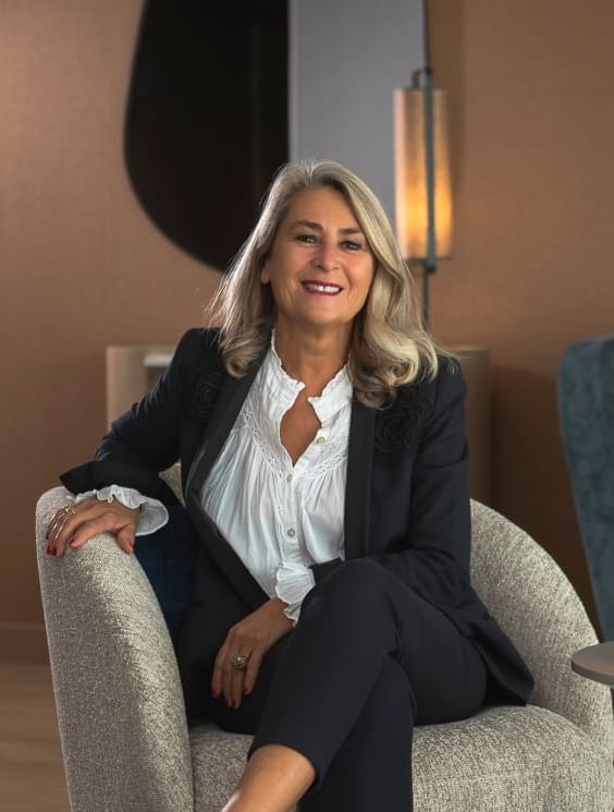 Portrait of a lady in a suit posing on a lobby lounge at Oceania Hotels