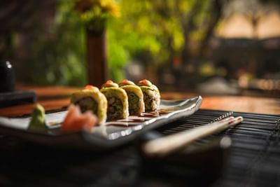 Close-up of a sushi platter with avocado rolls, wasabi, ginger, and chopsticks served at The Dwarika’s Hotels and Resorts
