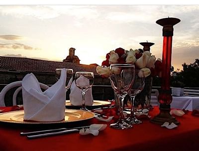 Sunlit table with crystal glasses and roses, elegantly arranged at Billini Hotel Historic Luxury