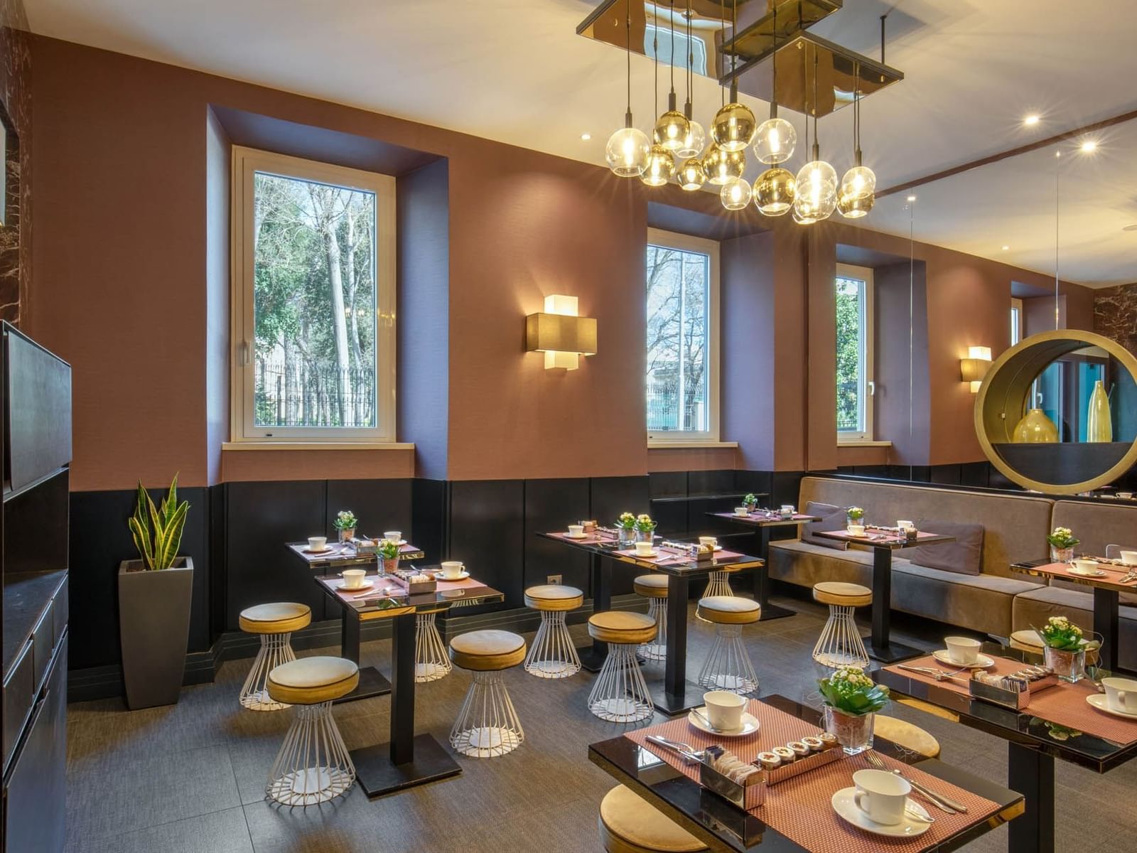 Elegant Breakfast restaurant at The Guardian Hotel with modern tables, stylish decor, and windows overlooking greenery