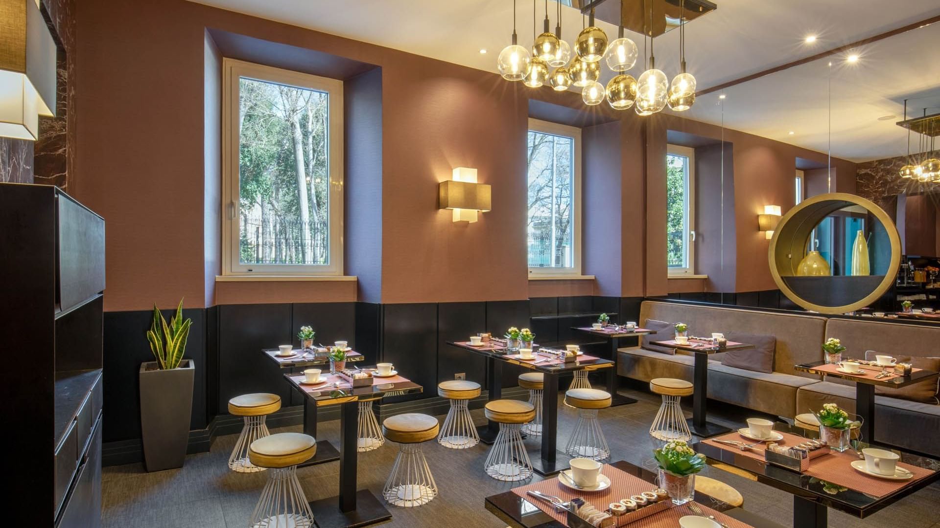 Elegant Breakfast restaurant at The Guardian Hotel with modern tables, stylish decor, and windows overlooking greenery