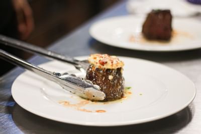 tongs plating up a delicious appetizer