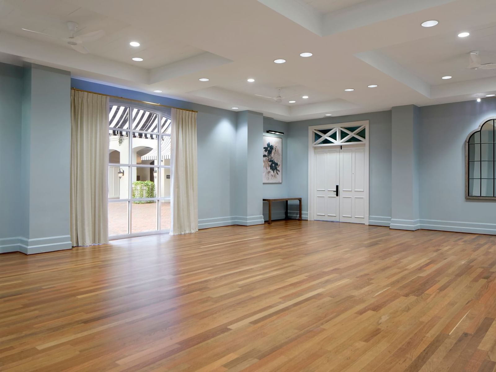 Orlando meeting venues of Orange Grove Room with wooden floor and a large window opening to the patio at Inn at Celebration