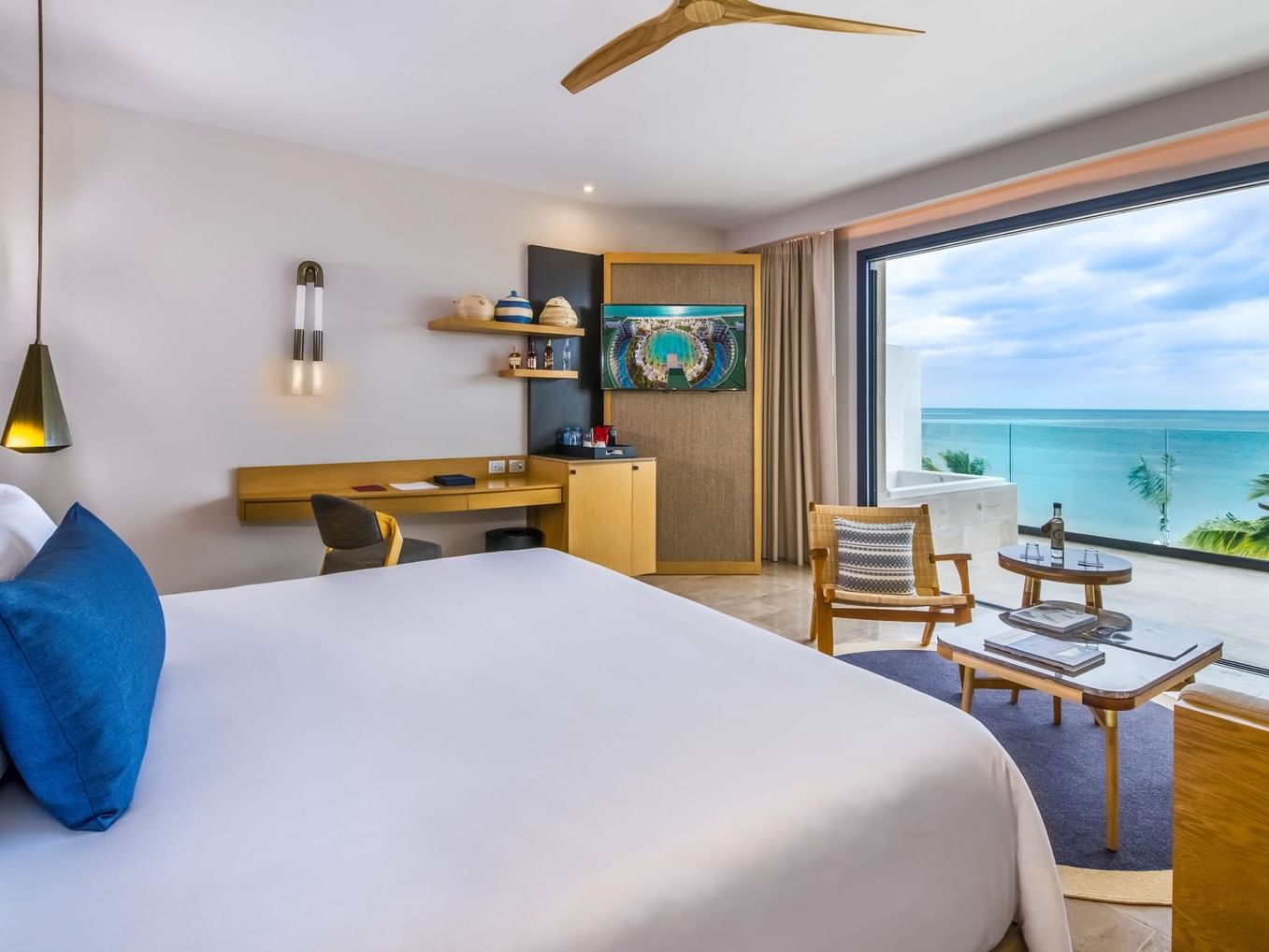 King bed, work desk, TV & balcony of Junior Suite Ocean Front View at Heaven Resort