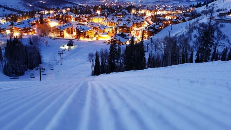 Skiing pathway with the illuminated city view near Chateaux Deer Valley