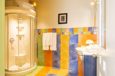 bathroom with rounded corner shower, funky and colourful tile