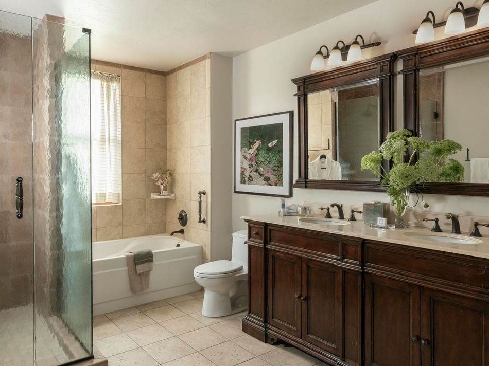 Presidential Suite bathroom featuring a wooden vanity & glass shower at Granduca Houston