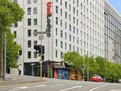 UniLodge building on street corner with trees and traffic lights