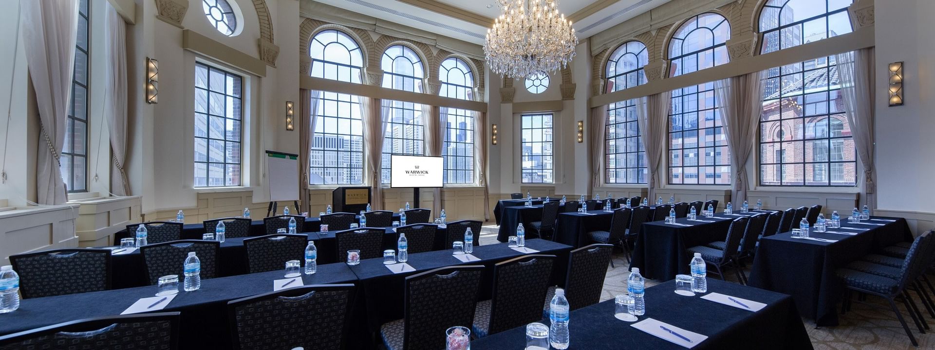 Classroom setup facing the projector screen near windows in Huron Room at Warwick Allerton Chicago