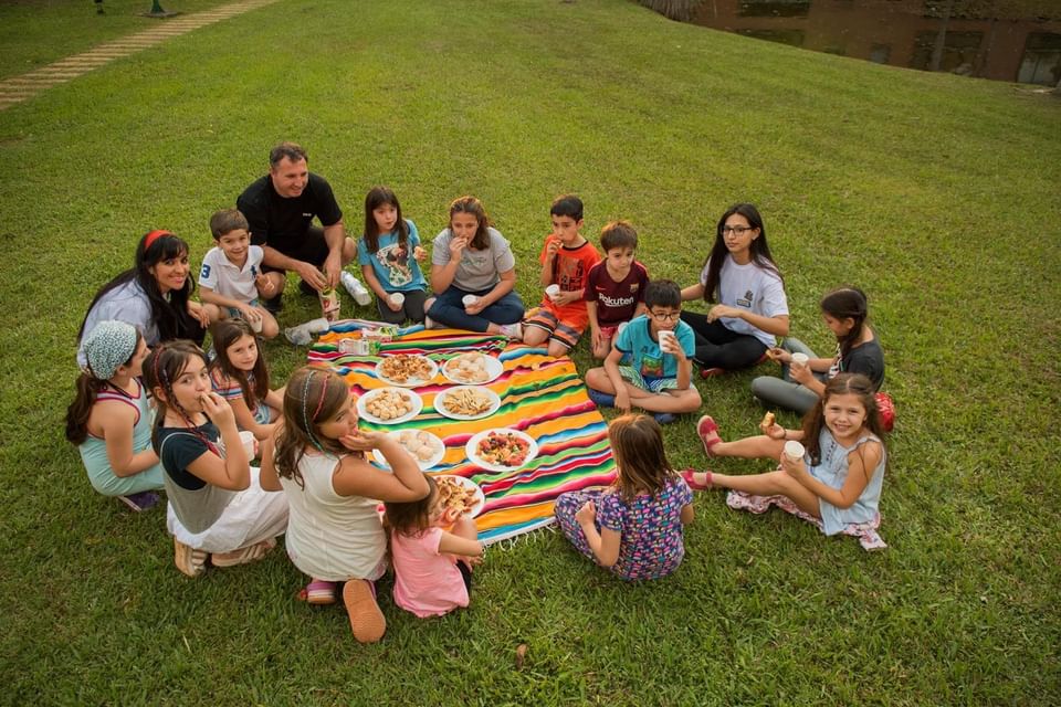 Um grupo de crianças jantando ao ar livre no Iguazu Grand Resort