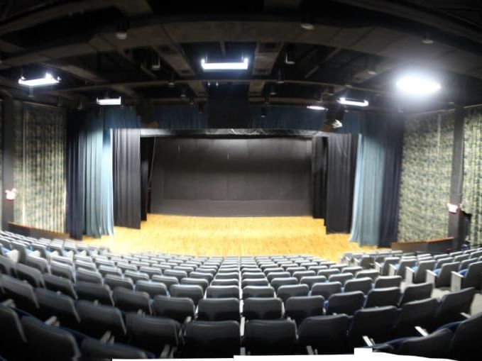 Top-down view of a theater stage with vacant seats in Courtleigh Auditorium at Courtleigh Hotel & Suites