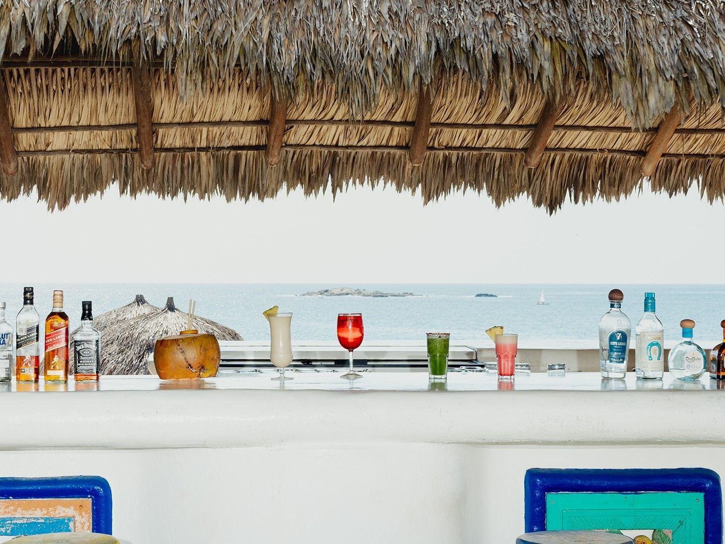 Various drinks served on the bar counter in Zaashila Beach Club with ocean views at Camino Real Zaashila Huatulco
