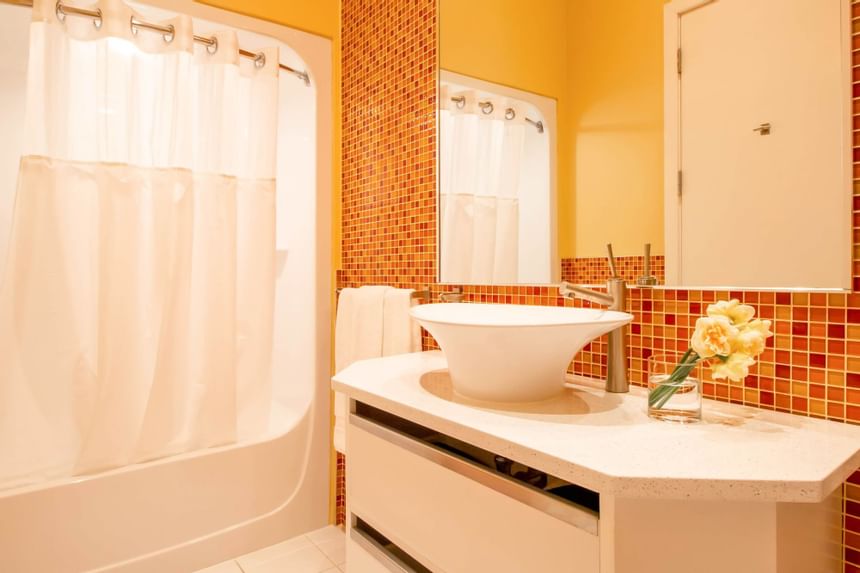 orange tile bathroom with raised white sink mirror 