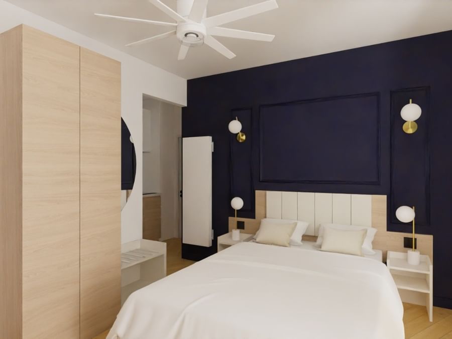 Chambre confortable avec lit blanc et mur bleu à Vichy, Les Sources Callou.