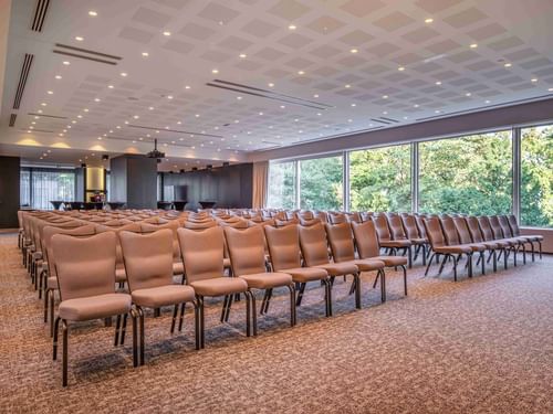 Park Ballroom with rows of beige chairs and patterned carpet at The Hotel Brussels