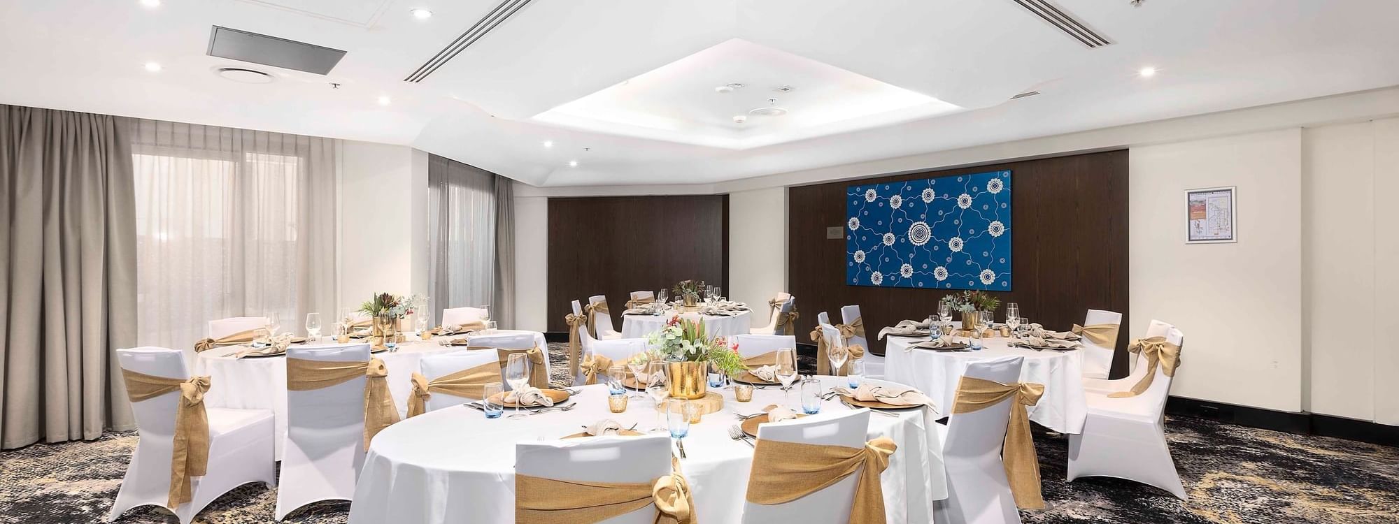 Set up banquets by the large windows with city views in The Yarra Room at Novotel Sydney on Darling Harbour