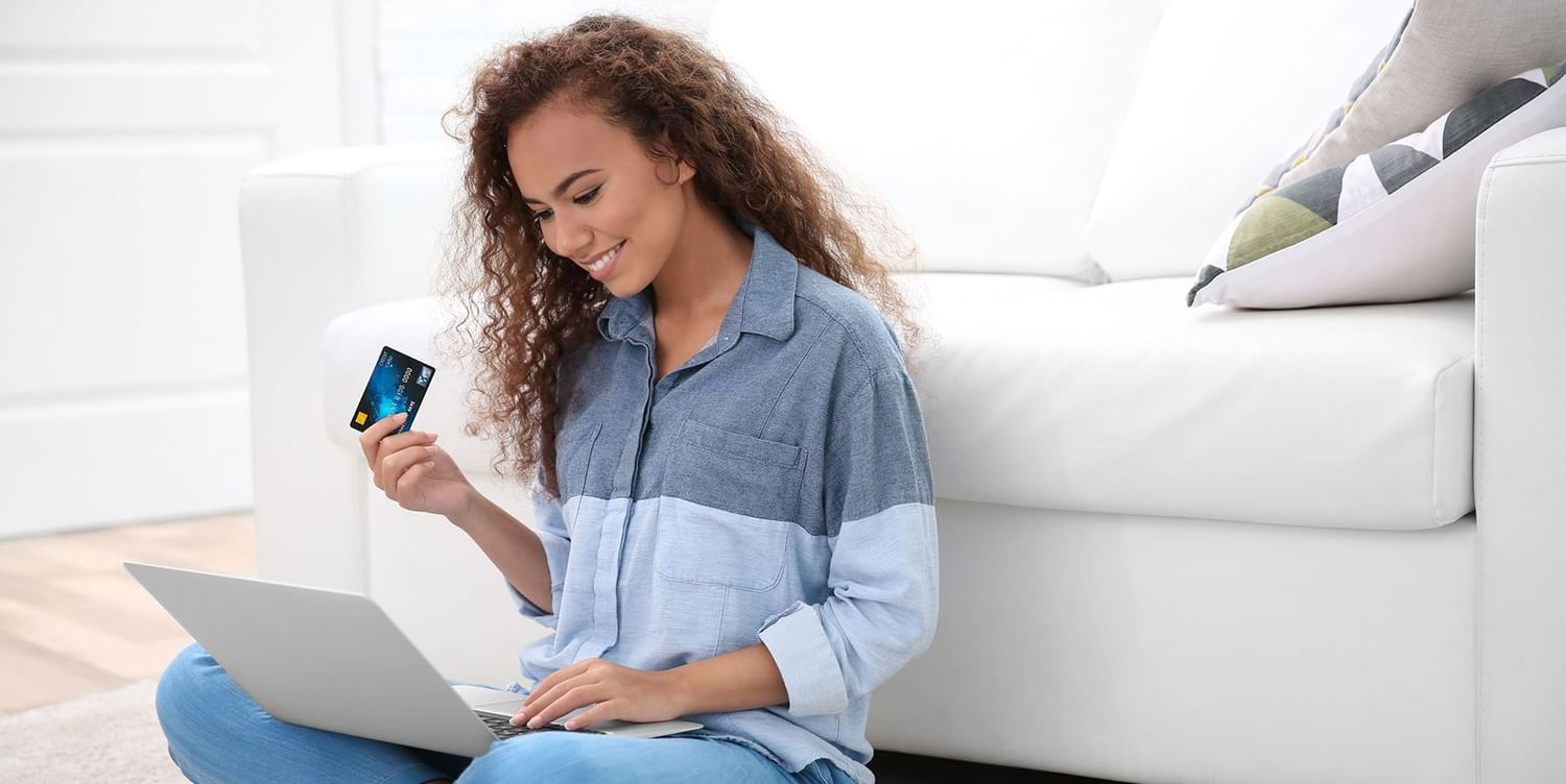 A woman checking her computer and smiling