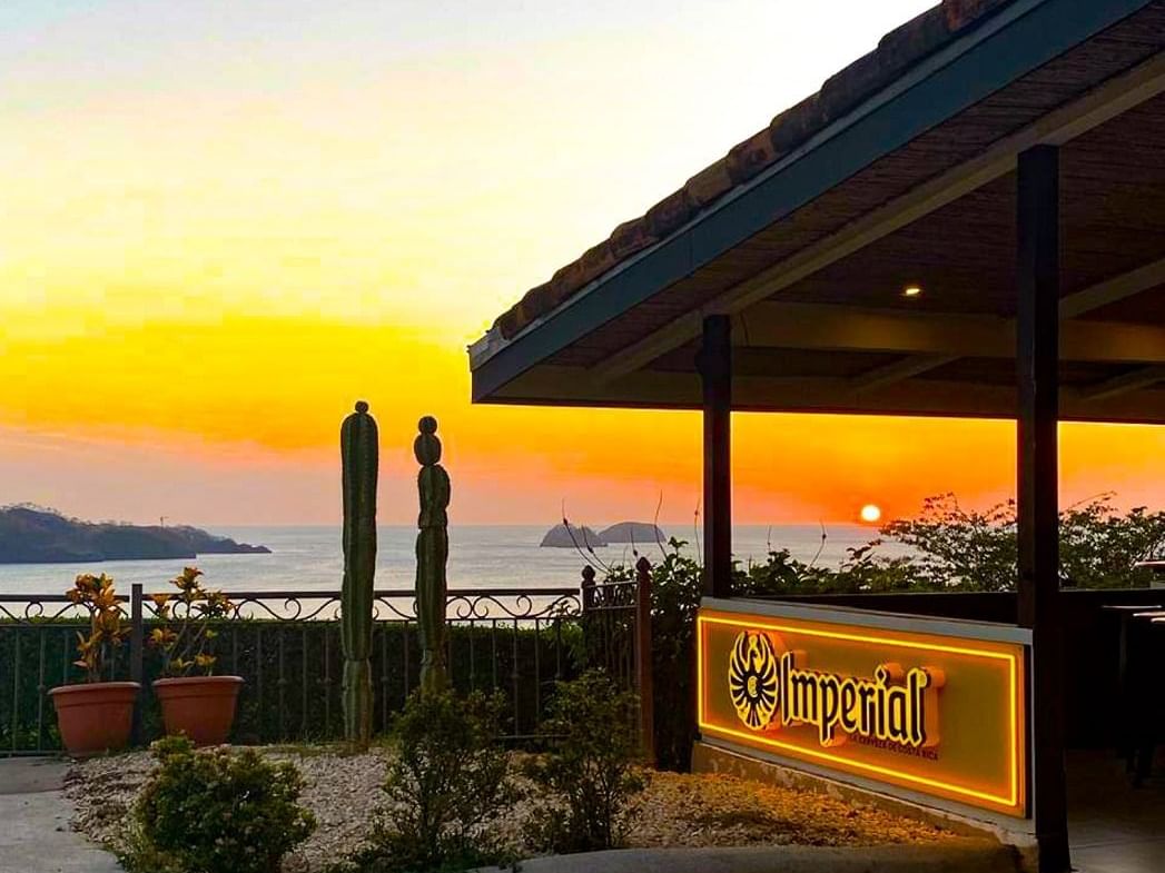 An exterior view of the Bar Imperial overlooking the sea in the evening from the Villas Sol Beach Resort