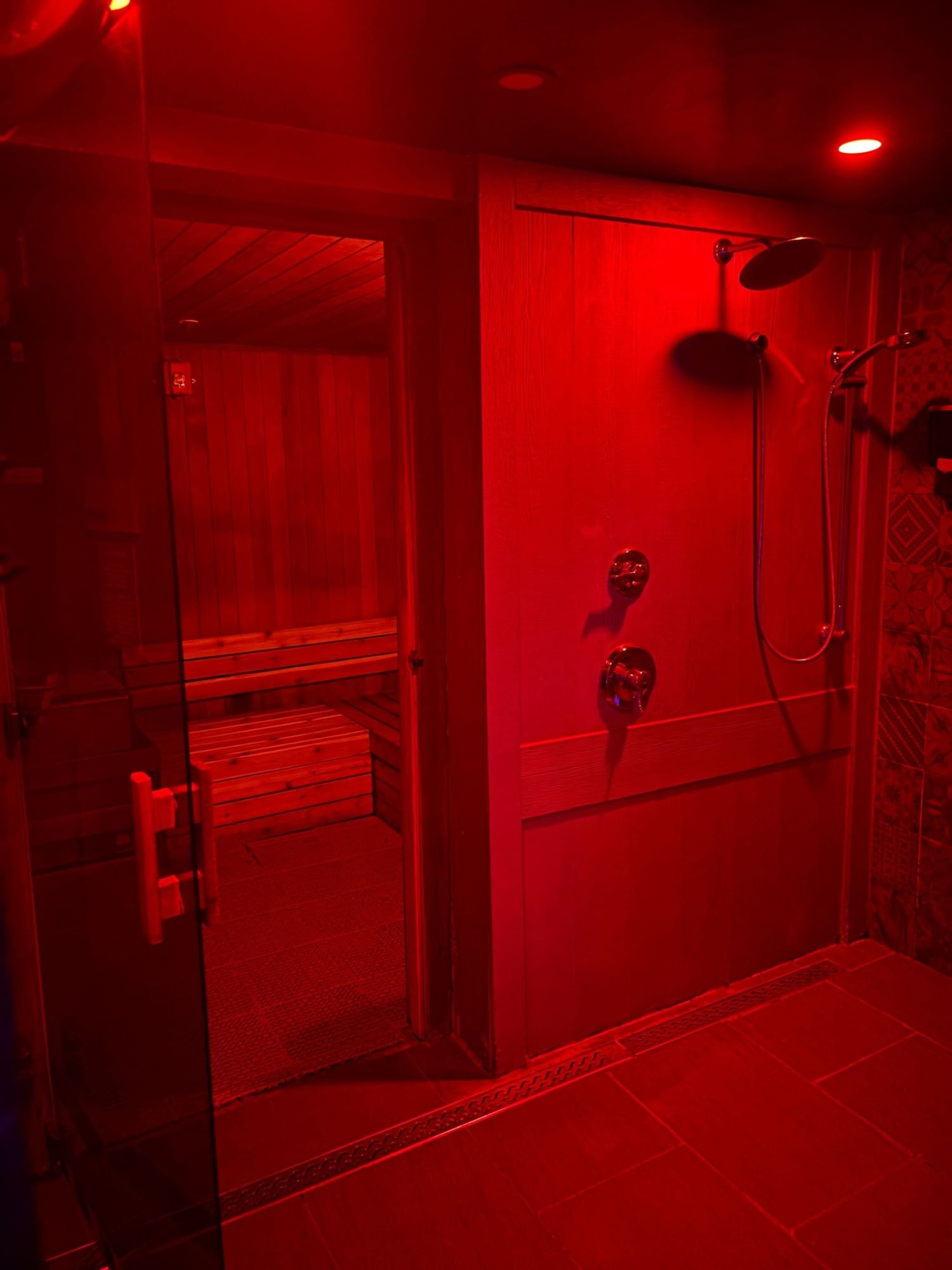 a red lit shower area with a bench