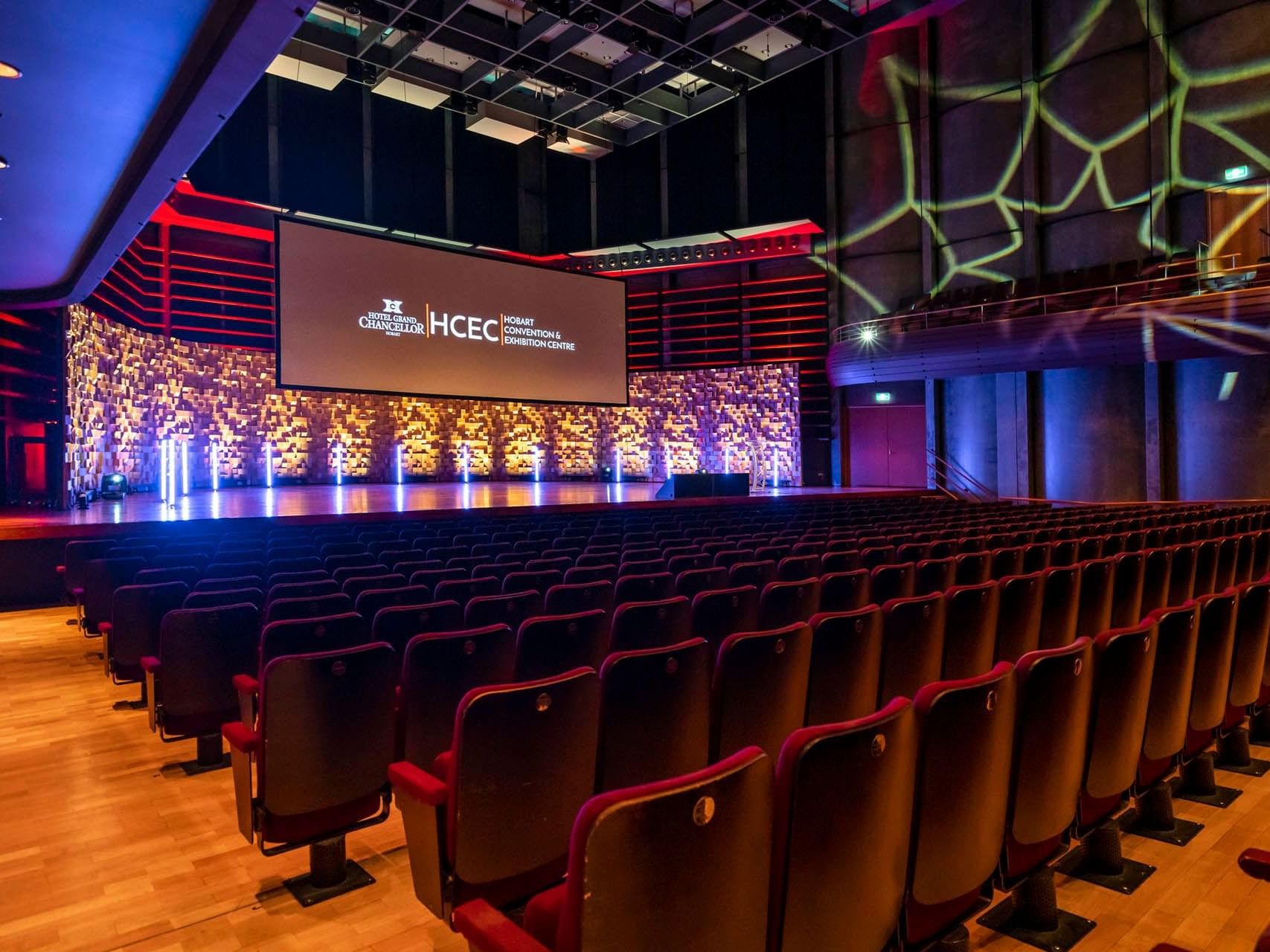 Interior of Federation Concert Hall with seats, stage & a large screen at Hotel Grand Chancellor Hobart