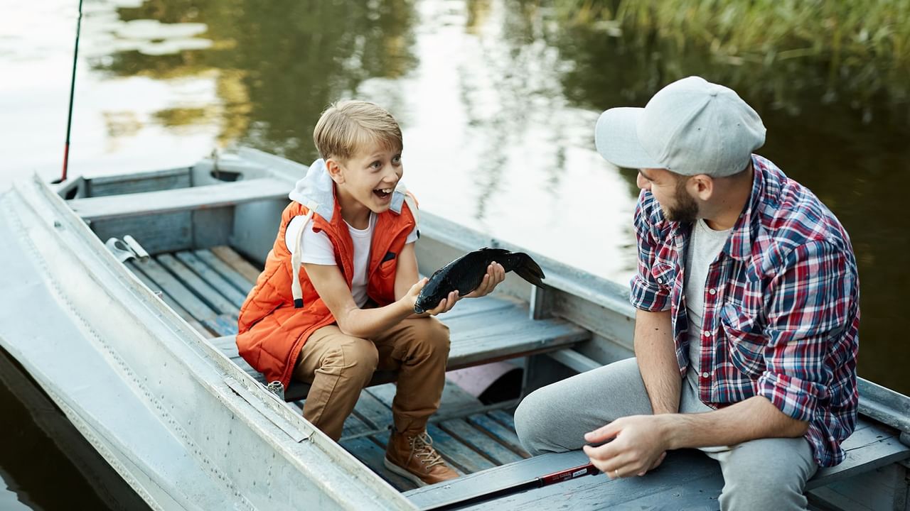 Son and Father in a boat holding a fish
