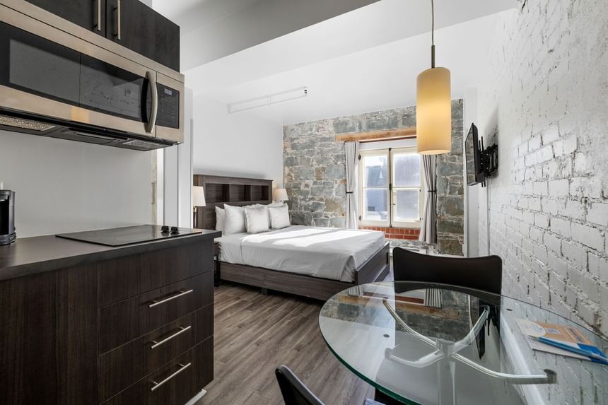 Galerie d'images - Chambre moderne avec des murs en pierre et une kitchenette dans un hotel vieux port Québec