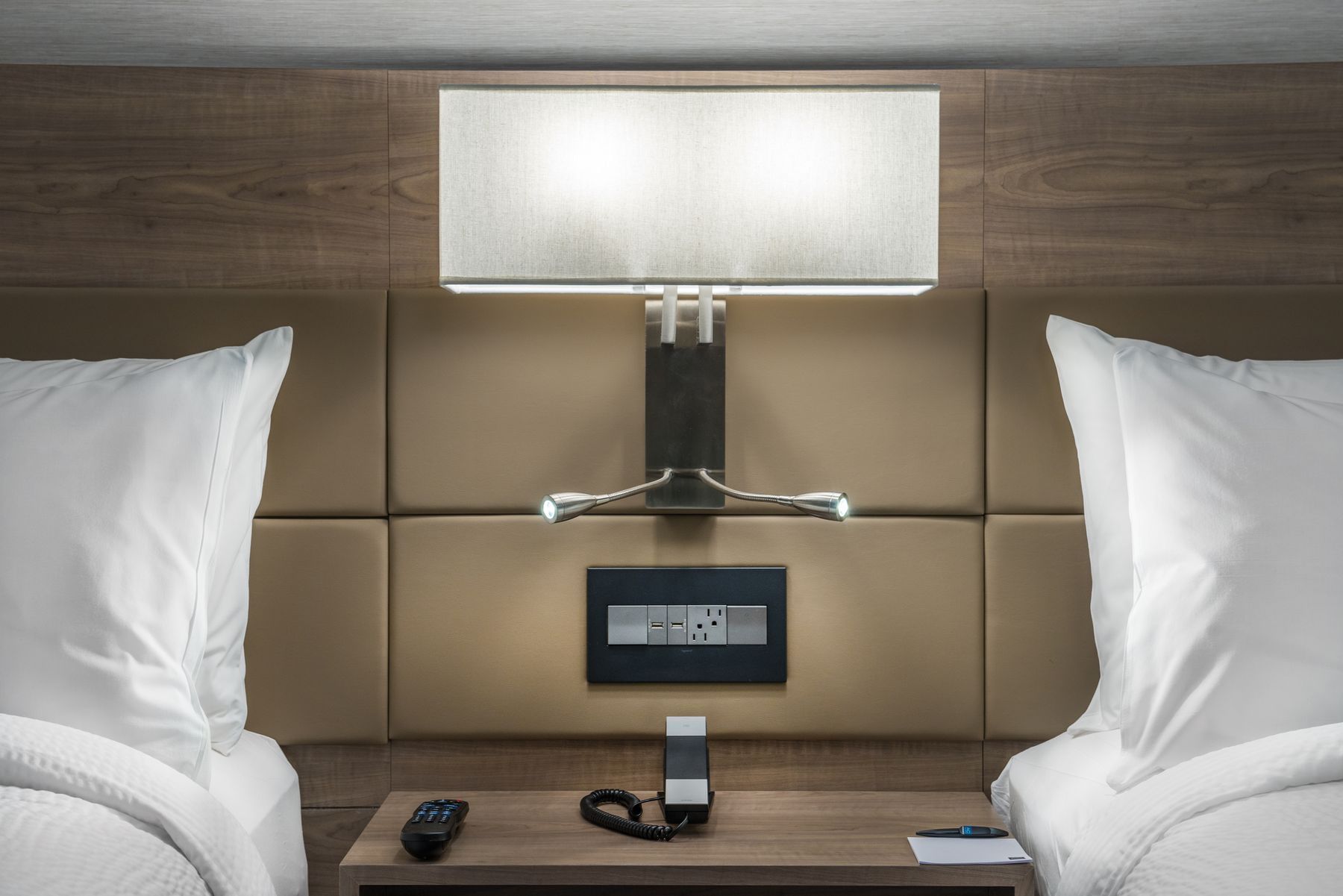 Lamp on nightstand between two beds