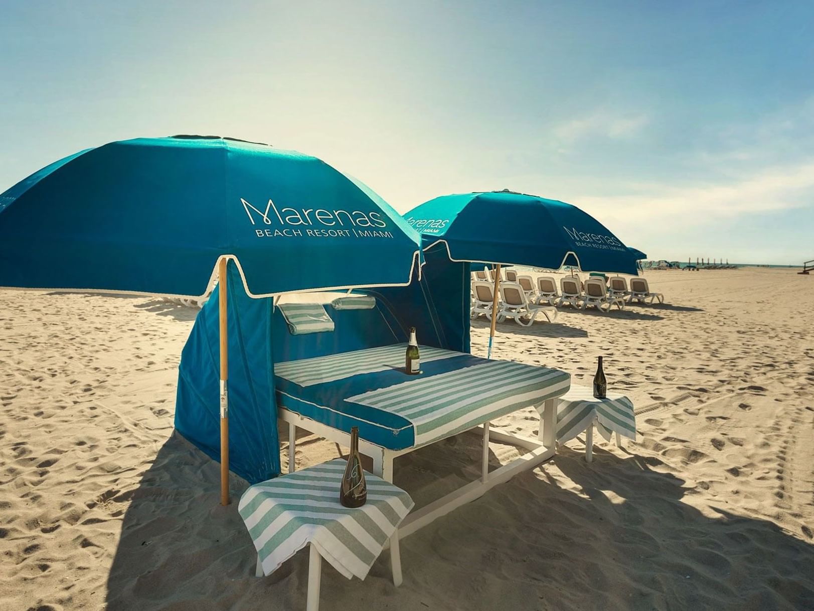 Beach chairs and tables by the beach at Marenas Resort Miami