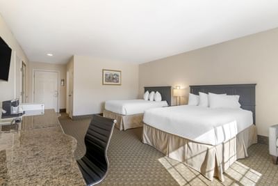 Bright Two-bedroom Suites at Ogunquit Hotel and Suites with two beds, a desk, a TV, and neutral lighting
