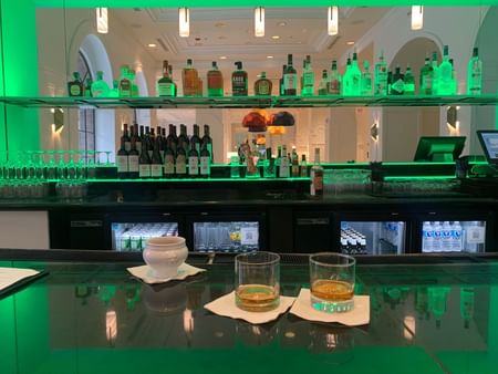 Bar counter with liquor bottles lined up on the rack at Warwick Allerton - Chicago