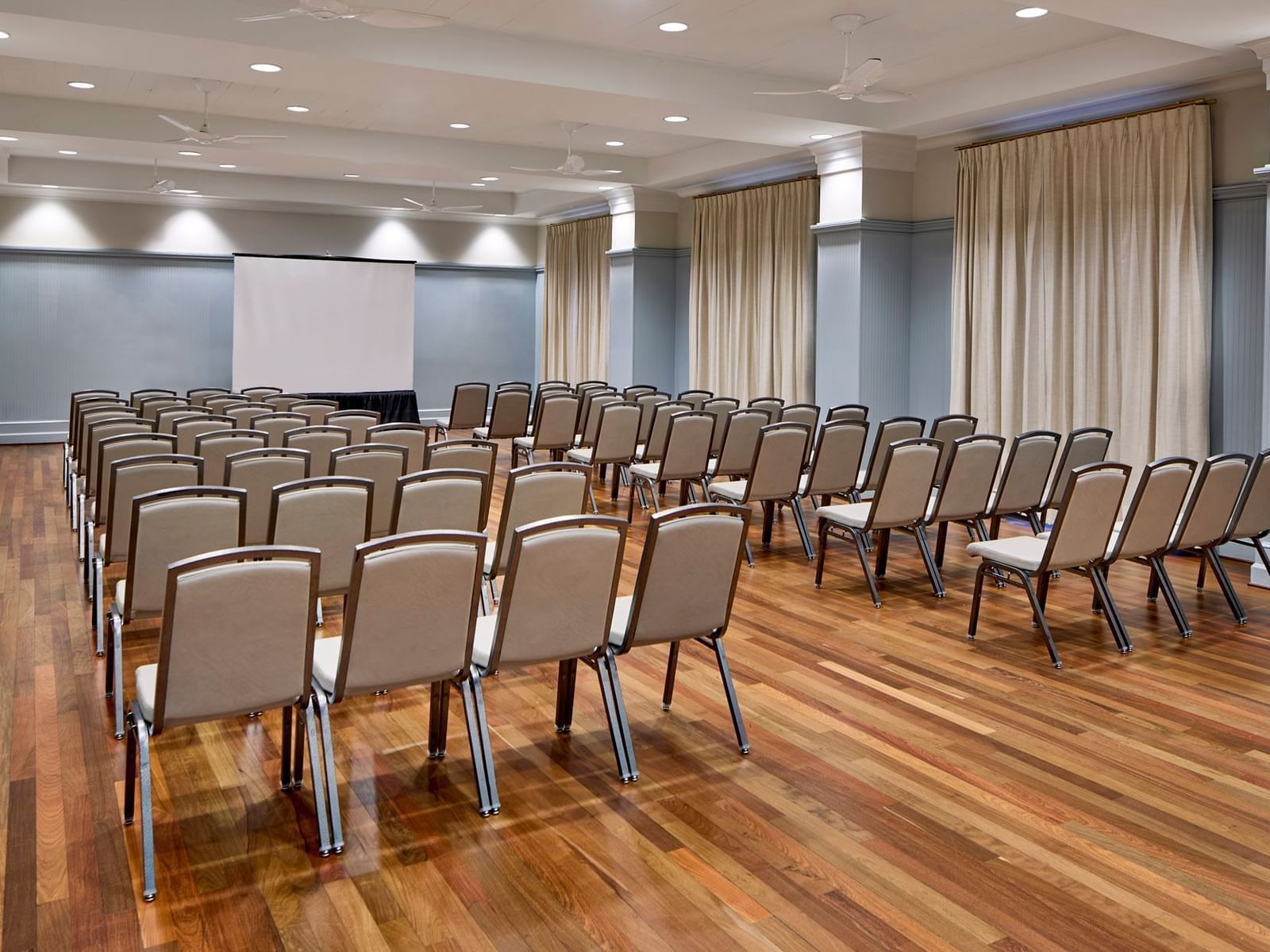 Theater set up facing the projector and wooden floors in Mockingbird Room at Inn at Celebration