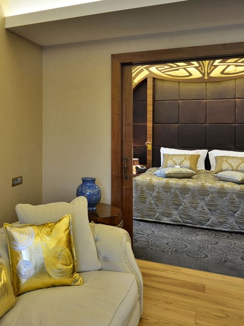 Cream sofa by a blue vase under a painting surrounding a bedroom doorway in Warwick Suite with Terrace at Warwick Ankara