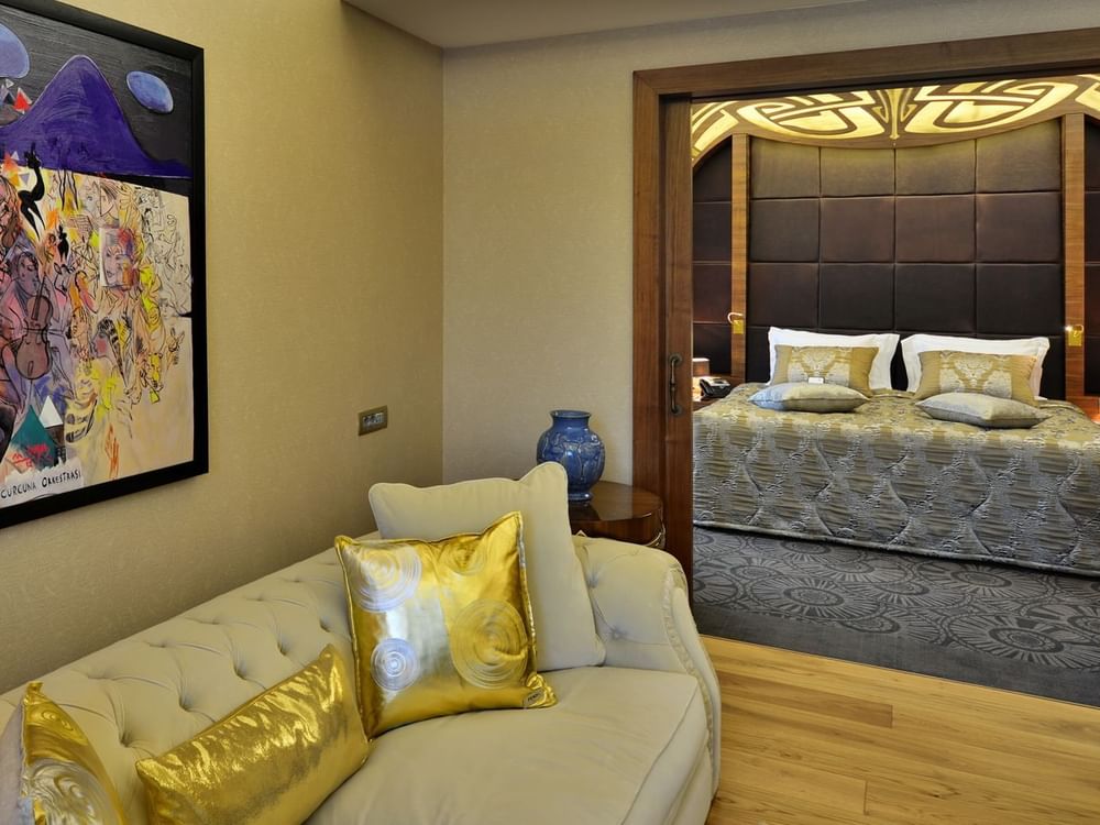 Cream sofa by a blue vase under a painting surrounding a bedroom doorway in Warwick Suite with Terrace at Warwick Ankara