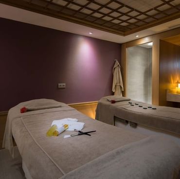 Zwei Massageliegen mit Annehmlichkeiten im BeFine Spa im Titanic Gendarmenmarkt Berlin.