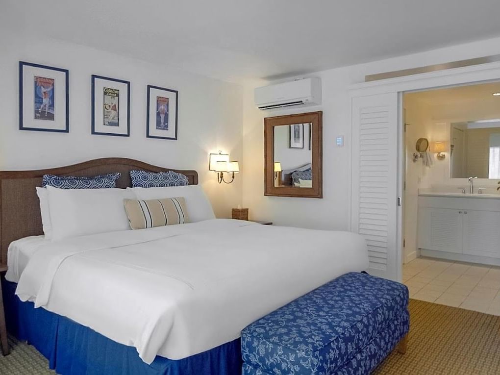 Comfy bed and bathroom vanity in Premier King Rooms at Catalina Island Company, one of the catalina island rooms