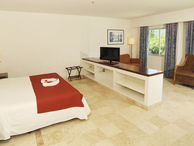 Master Suite with a king bed facing a TV at Gamma Hotels