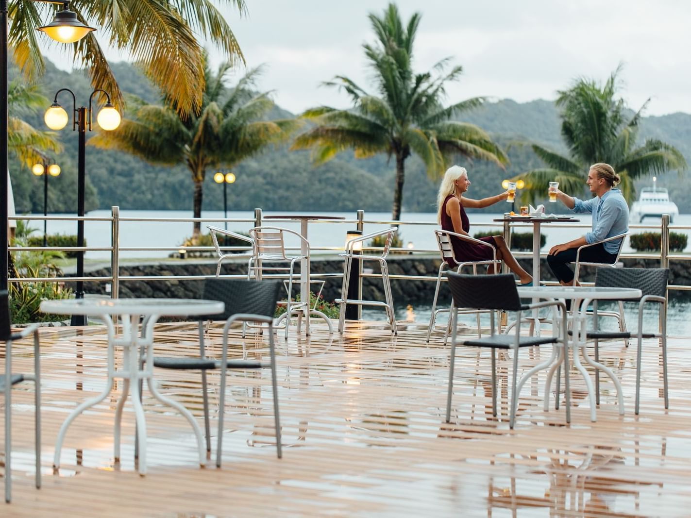 A couple toasting cocktails in Breeze Bar at Palau Royal Resort