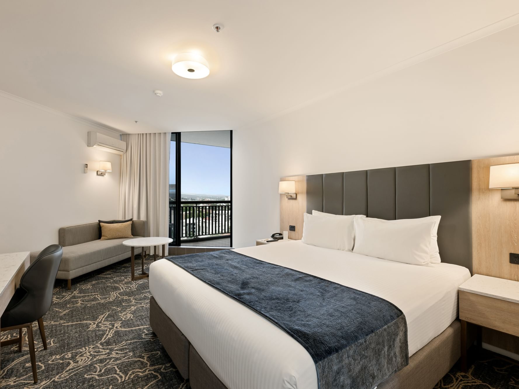 Large bed with side lamp in Superior King High Floor Balcony Room at Hotel Grand Chancellor Brisbane
