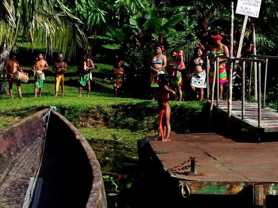 Indios embera de pie cerca del agua / plataforma