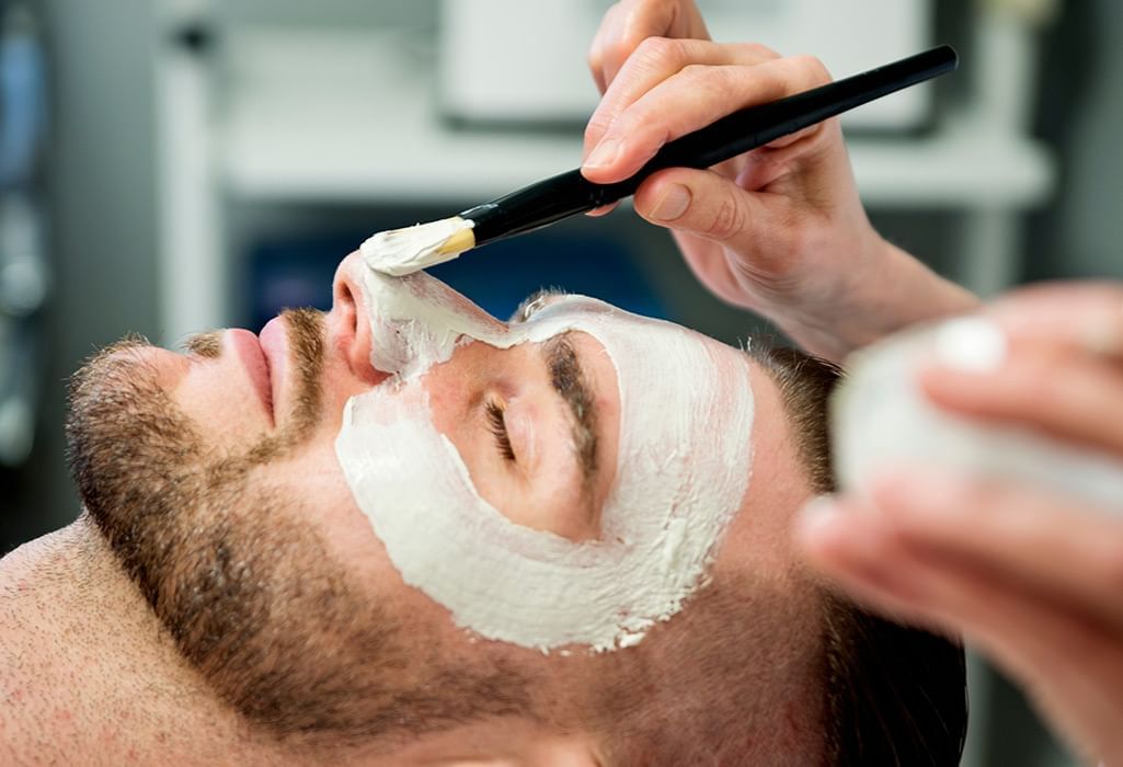 man receiving a facial by someone holding a brush